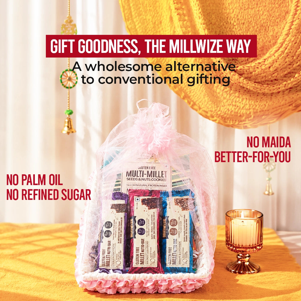 A gift basket of Millwise branded granola bars wrapped in a clear mesh bag with a pink ruffled base, displayed on a yellow draped table with decorative hanging ornaments and a candle. Text overlays highlight product benefits.